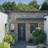 Porte d'entrée vitrée en aluminium TOURBE 1 sur une façade de maison contemporaine
